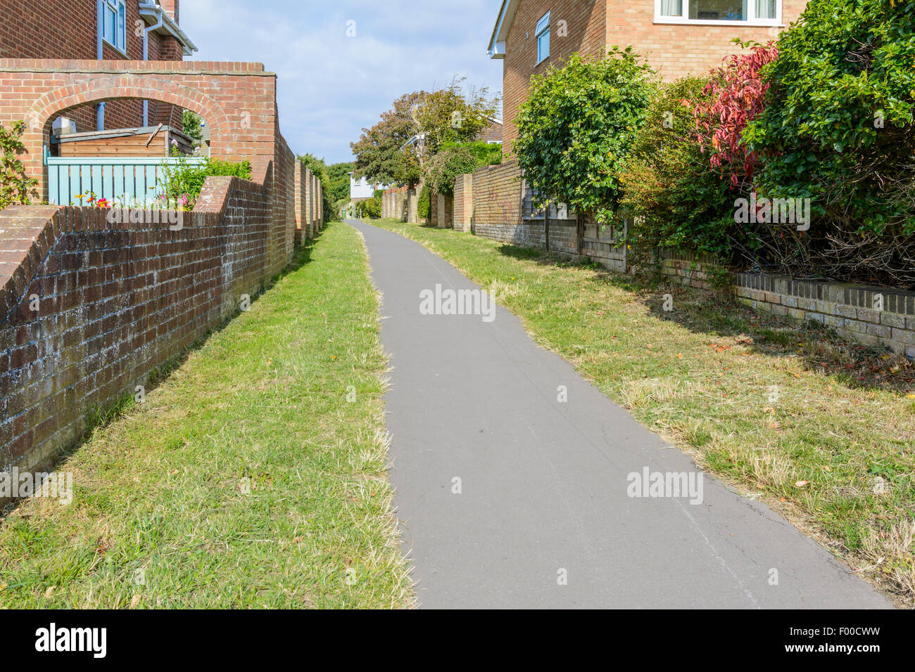 Schmale Gasse oder Twitten Passage Weg zwischen den Häusern in einem Wohngebiet in Großbritannien. Stockfoto