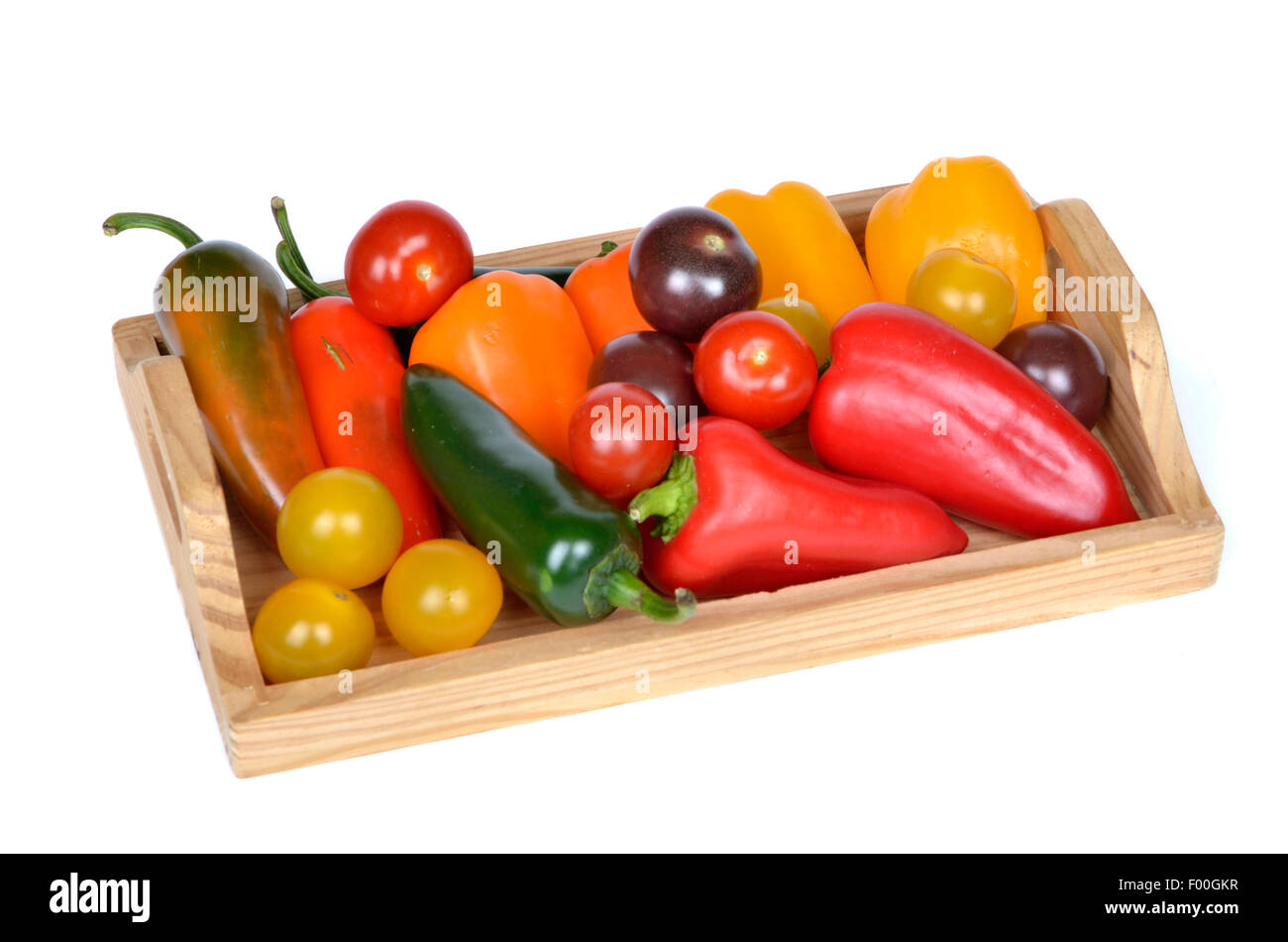 verschiedene Arten von Chili, Paprika und Tomaten auf einem Holztablett Stockfoto