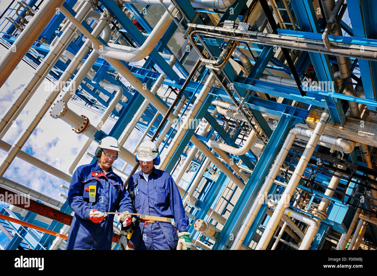 Raffinerie Arbeitnehmer und riesige pipelines Stockfoto