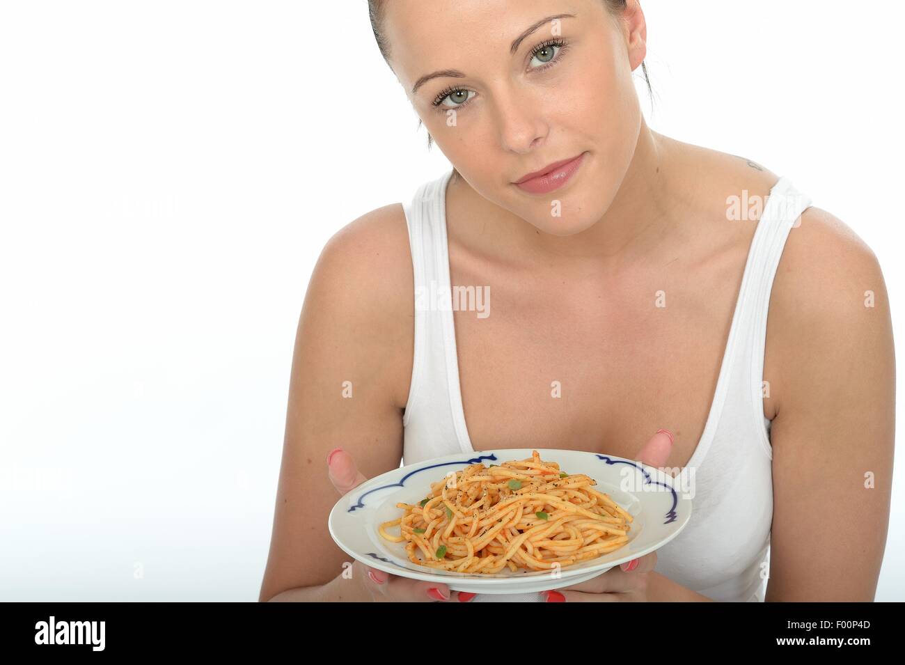 Zuversichtlich Positive junge Frau mit einer Platte des Italienischen mediterranen Stil Spaghetti Pasta in Tomatensauce Isoliert gegen einen weißen Hintergrund Stockfoto