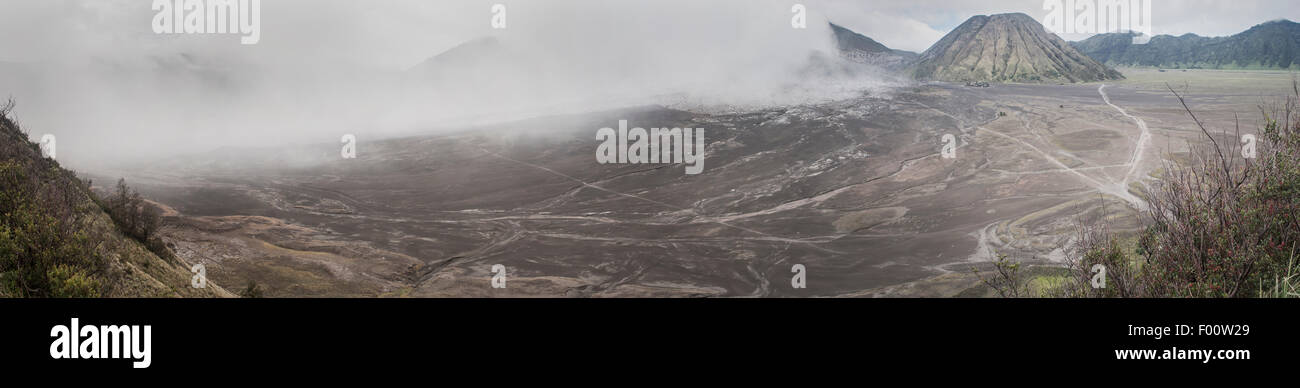 Regen-Wolken-Rolle an der Seite des Berges (Gunung) Bromo; Nationalpark Bromo-Tengger-Semeru, Indonesien. Stockfoto