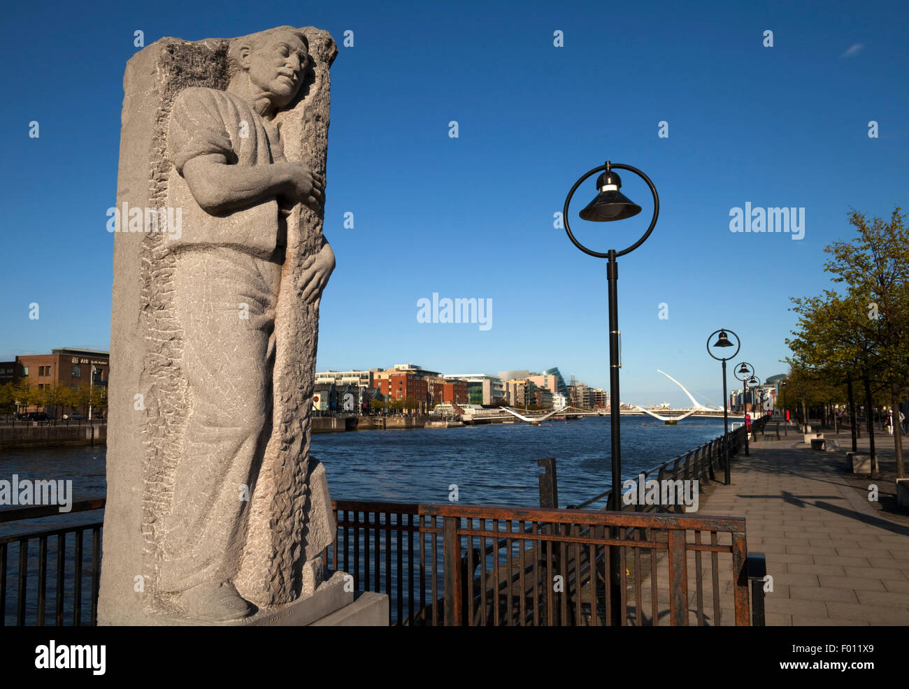 Skulptur von Matt Talbot durch James Power, mit weit entfernten Sean O' Casey Bridge hinunter zum Fluss Liffey, Stadt Dublin, Irland Stockfoto