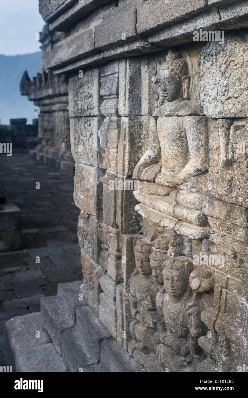 Wand, Schnitzen mit der Buddha im 9. Jahrhundert buddhistischen Tempel, Borobudur, Java, Indonesien. Stockfoto