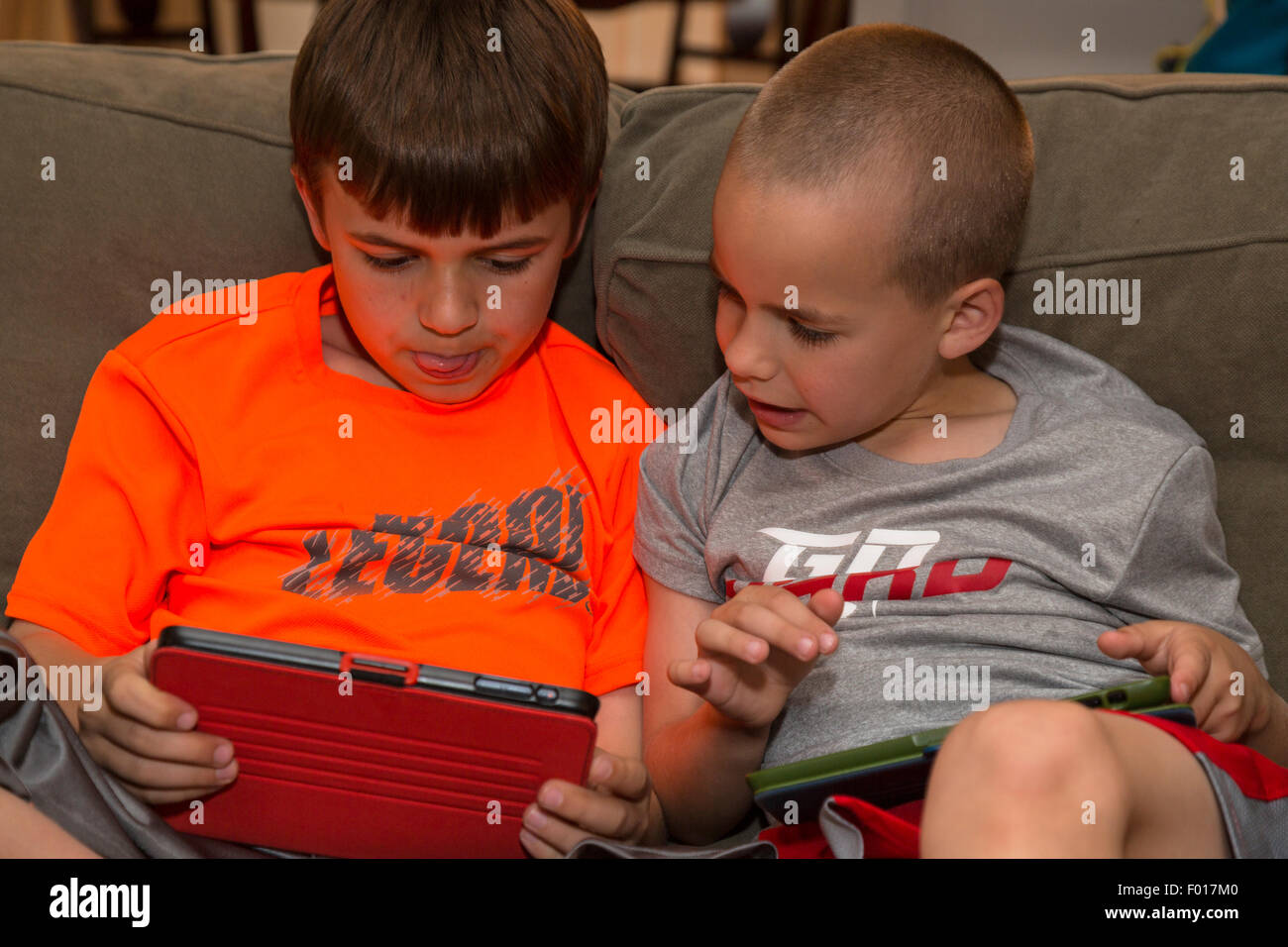 Zwei Brüder spielen Spiele auf ihren iPads.  HERR Stockfoto