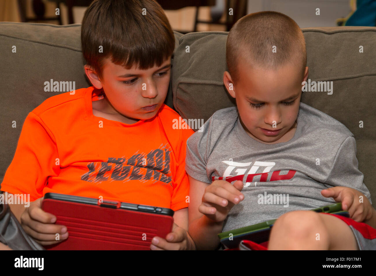 Zwei Brüder spielen Spiele auf ihren iPads.  HERR Stockfoto