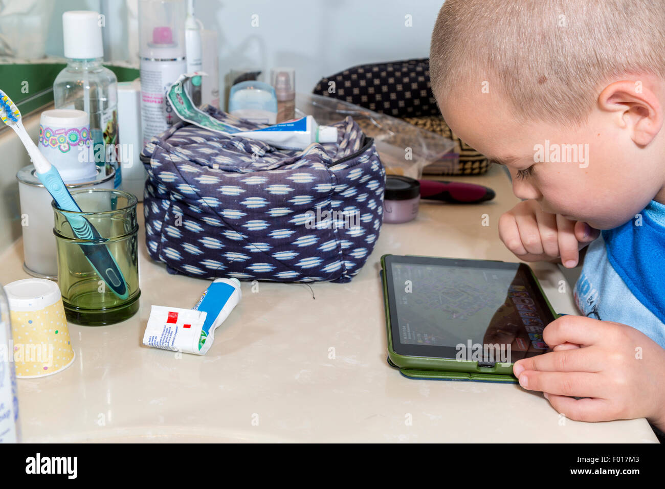Computer Videospiele spielen verlangsamt Seven-Year-Old Boy Zähneputzen am Ende des Tages.  HERR Stockfoto