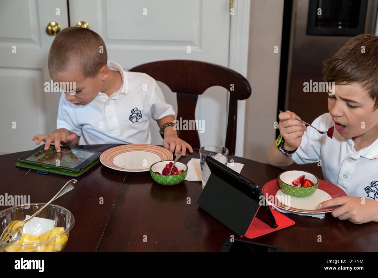 Das moderne Kind: Frühstück mit Videospielen.  HERR Stockfoto