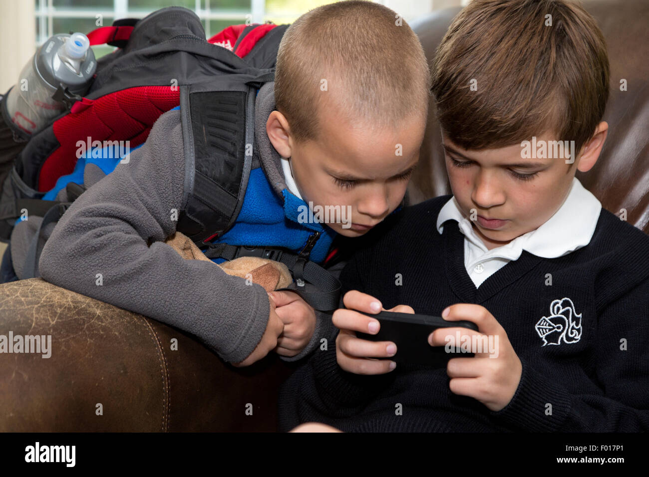 Jüngerer Bruder (Alter 7) gerade älterer Bruder (Alter 9) mit seinem iPod.  HERR Stockfoto