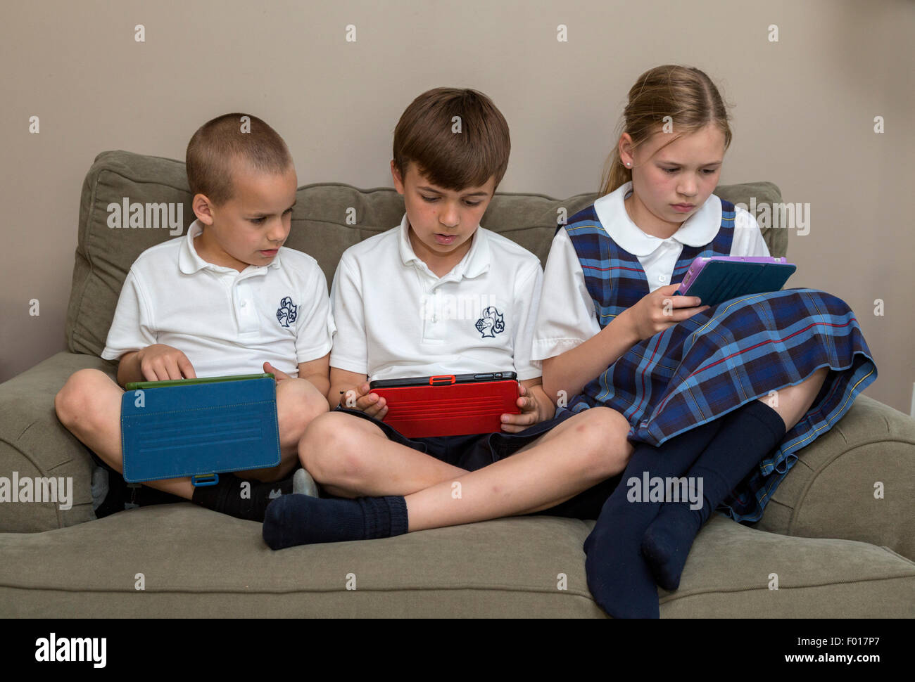Modern Family zu Hause nach der Schule: Kinder mit ihren iPads.  MR.  Beachten Sie die Reihenfolge mit  PER5313, 5315 und 5316. Stockfoto