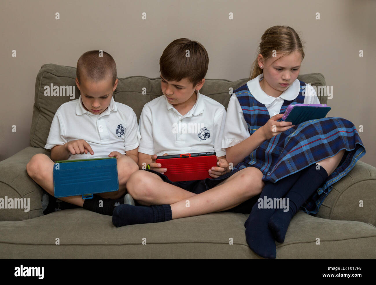 Modern Family zu Hause nach der Schule: Kinder mit ihren iPads.  MR.  Beachten Sie die Reihenfolge mit  PER5313, 5314 und 5316. Stockfoto