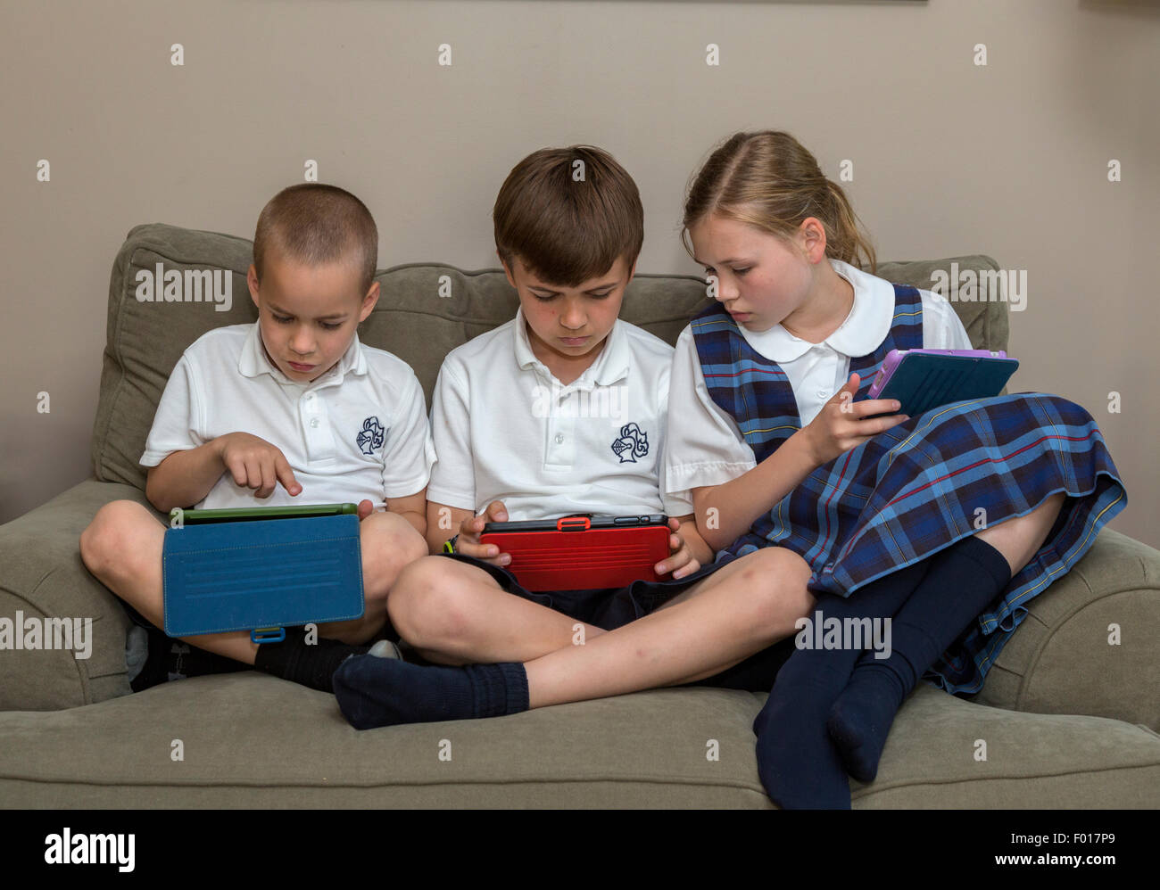 Modern Family zu Hause nach der Schule: Kinder mit ihren iPads.  MR.  Beachten Sie die Reihenfolge mit  PER5313, 5314 und 5315. Stockfoto