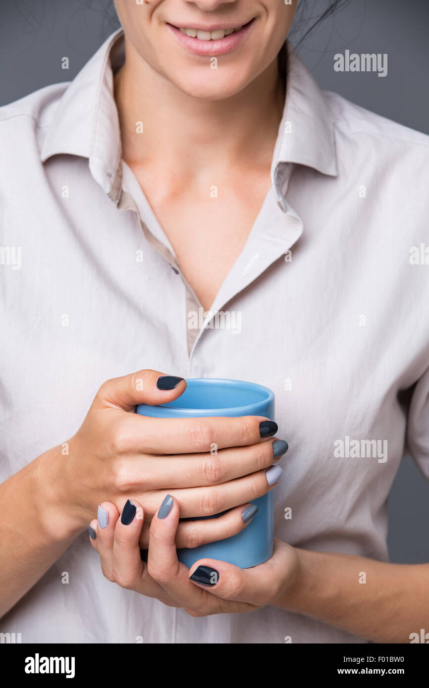 Weibliche Hände mit blauen Tasse Stockfoto