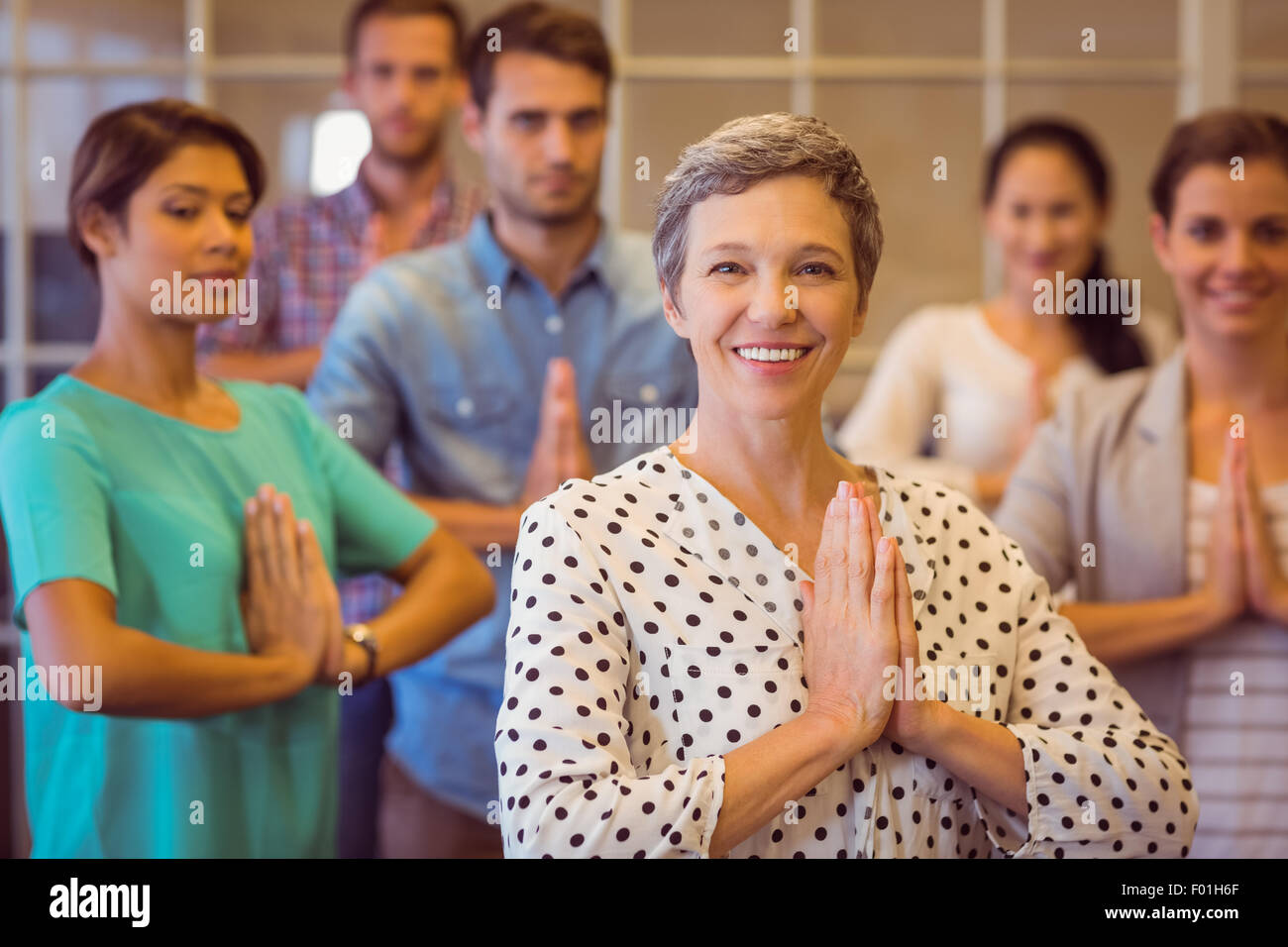 Kreative Geschäftsfrau mit ihrem Teamarbeit zu beten Stockfoto
