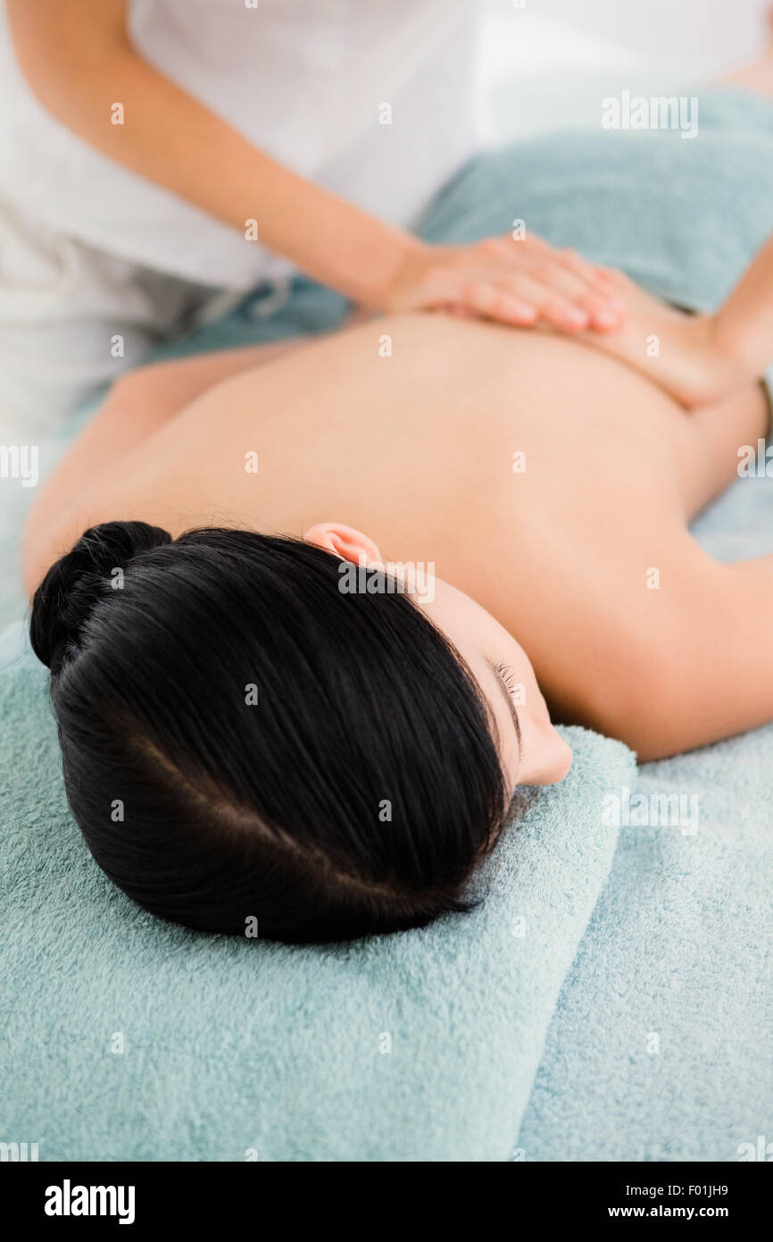 Attraktive Frau empfangen Rückenmassage im Wellnesscenter Stockfoto