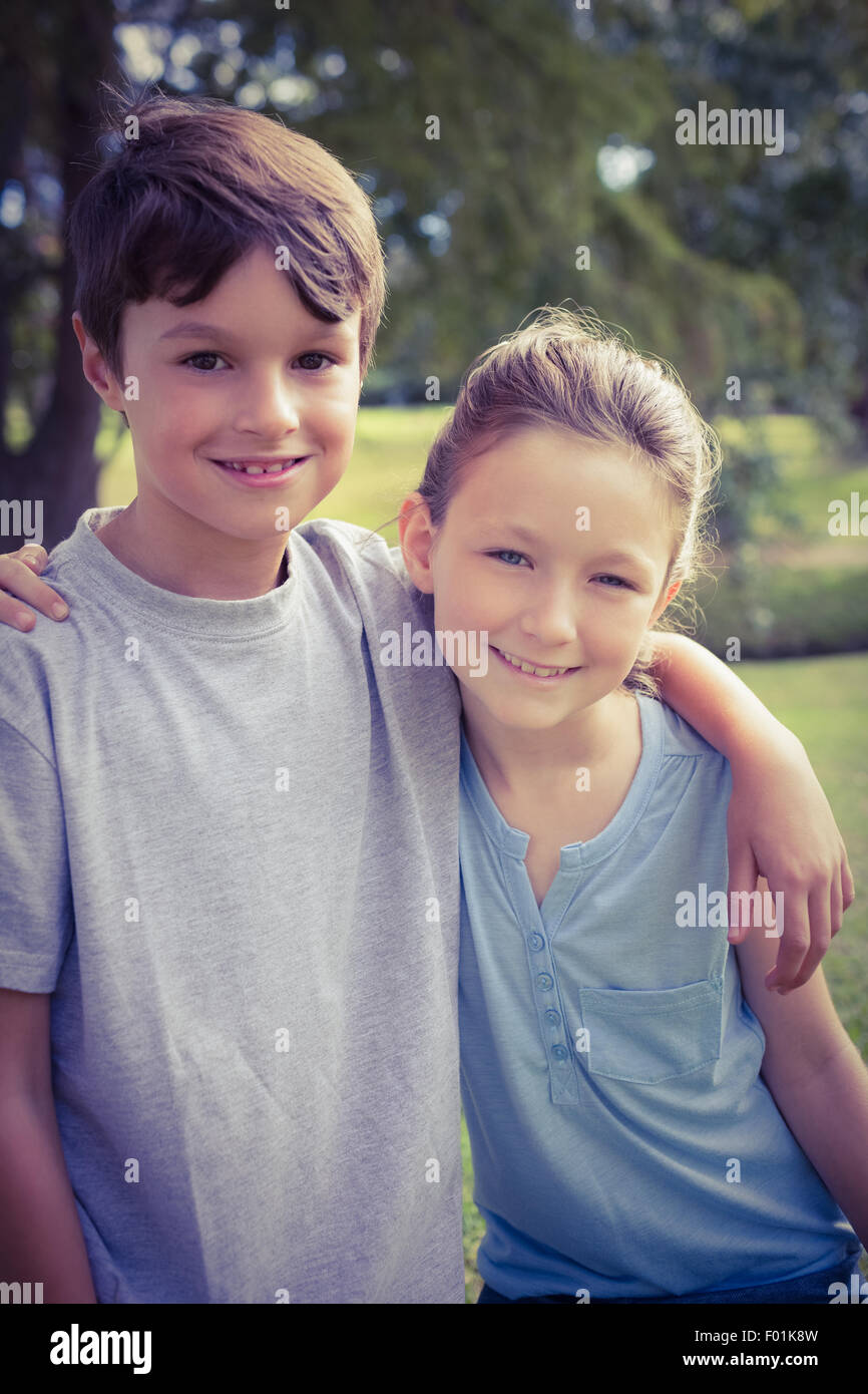 Lächelnde Geschwister Blick in die Kamera im park Stockfoto