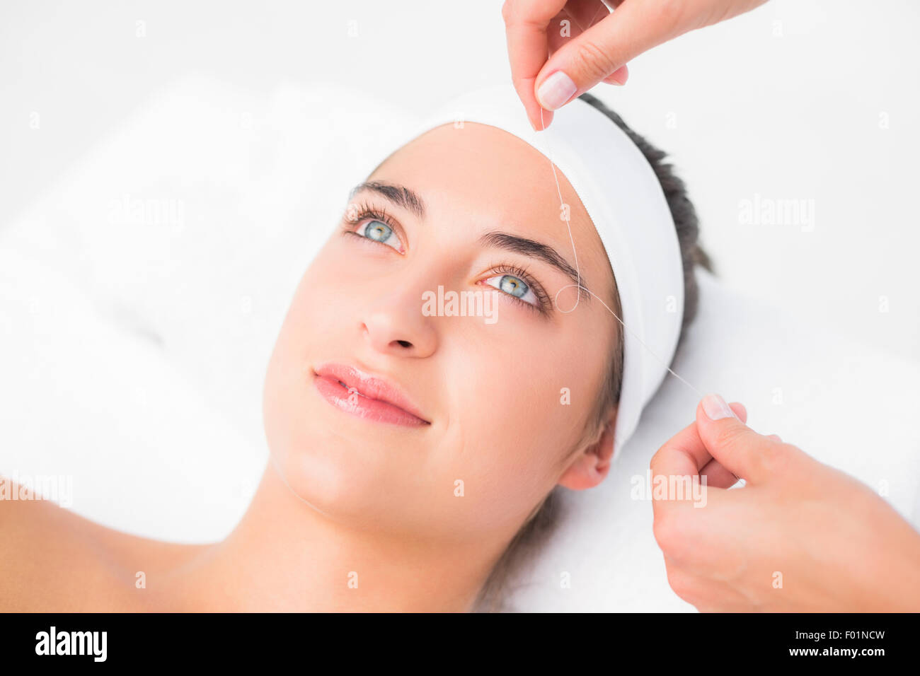 Hände, die schönen Womans Oberlippe Einfädeln Stockfoto