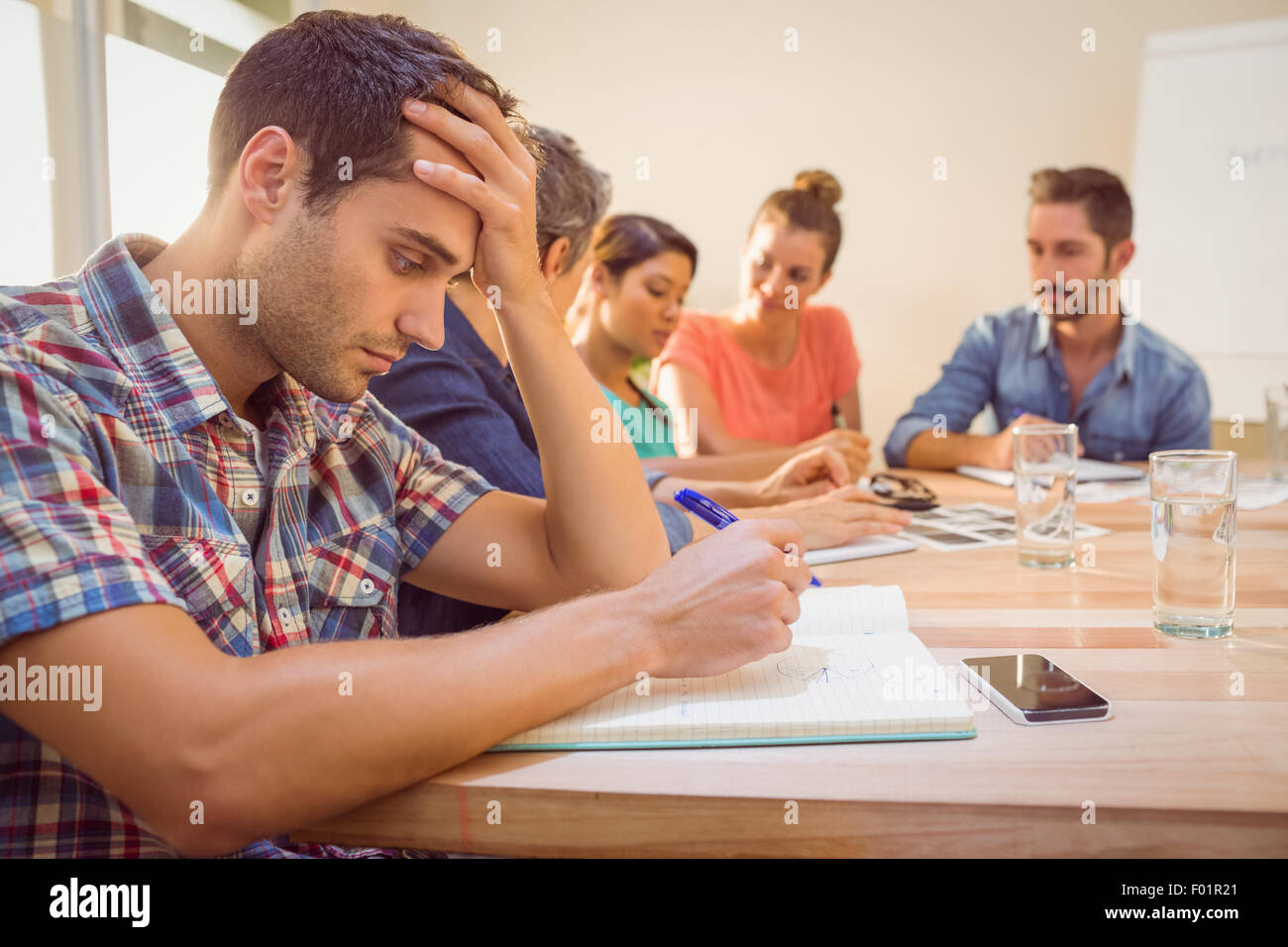 Besorgt lässige Geschäftsmann hören zu einer Konferenz Stockfoto