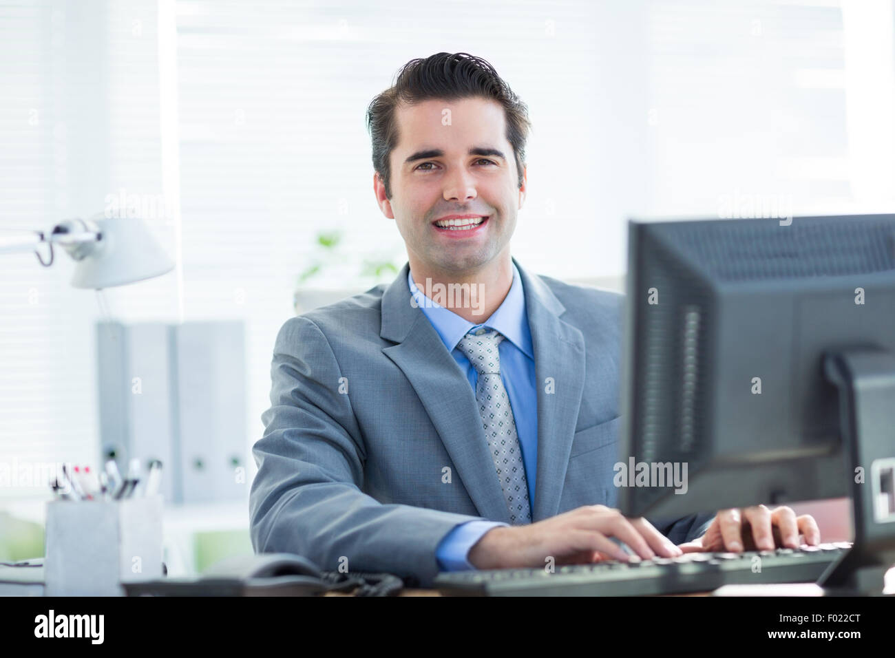 Lächelnde Geschäftsmann mit seinem computer Stockfoto