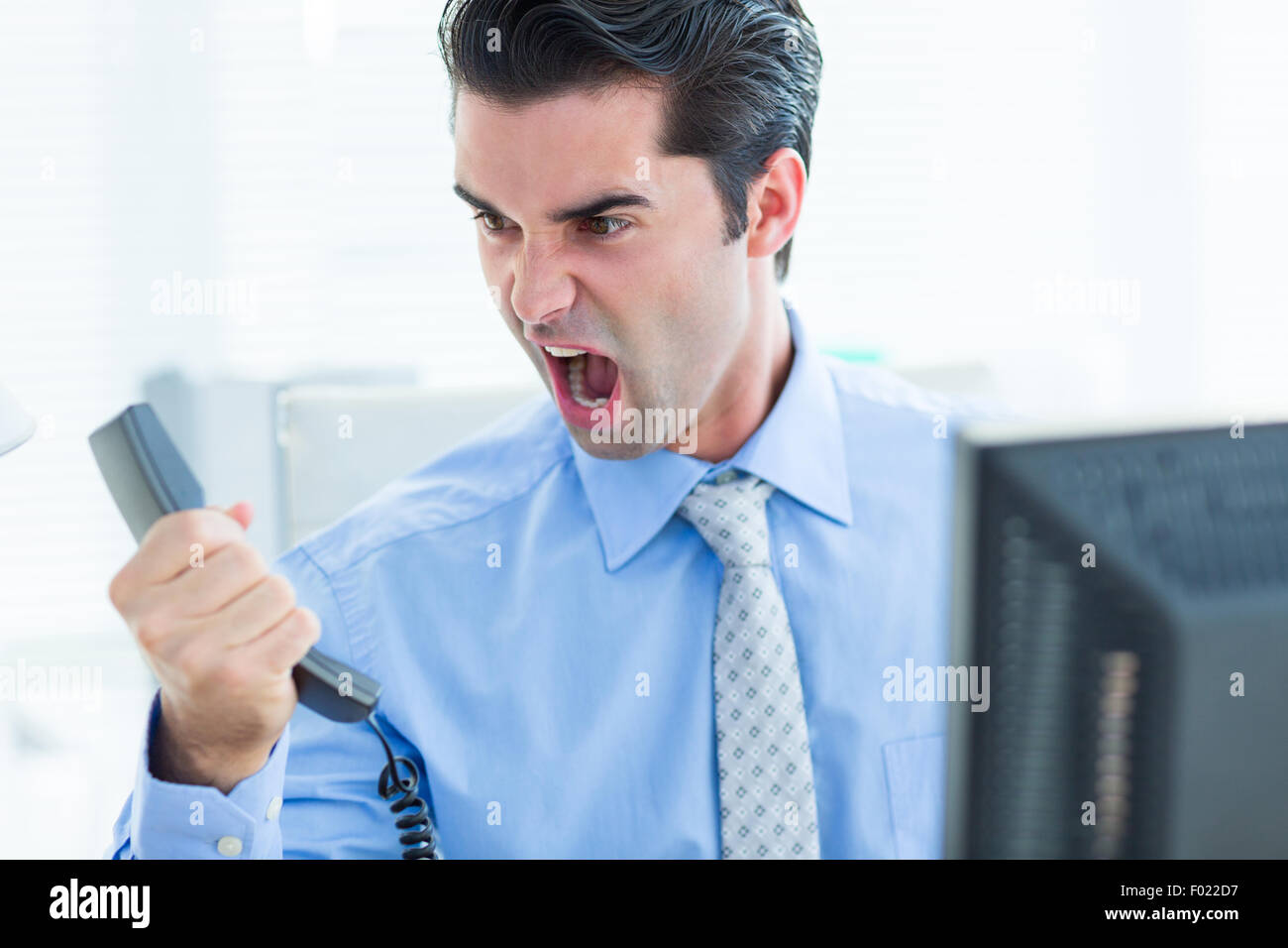 Geschäftsmann, schreien, als er hält, Telefon im Büro Stockfoto