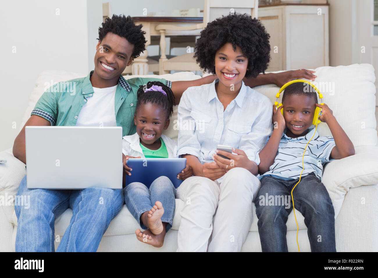 Glückliche Familie mit Technologien auf der couch Stockfoto