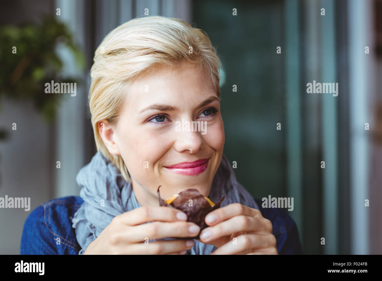 Lächelnde Blondine ein Muffin Kuchen Stockfoto