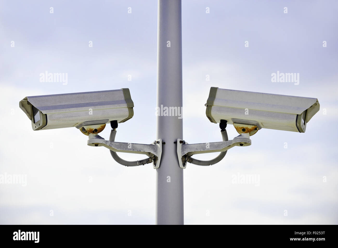 Zwei Überwachungskameras auf einem Mast mit blauen Himmel im Hintergrund Stockfoto