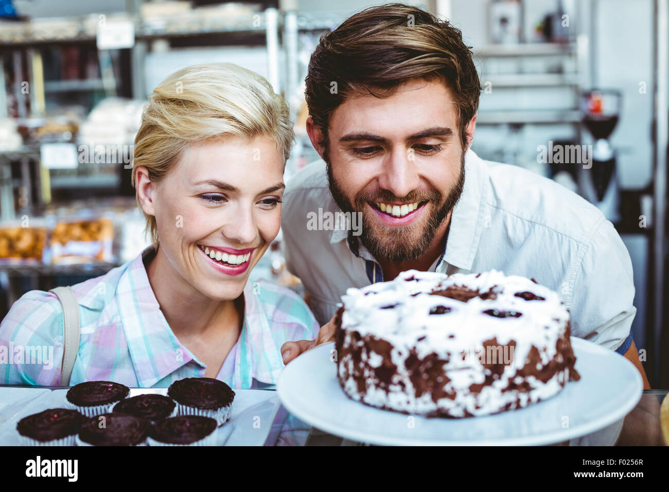 Süßes Paar an einem Datum betrachtet man einen Schokoladenkuchen Stockfoto