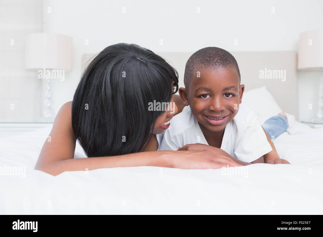 Hübsche Mutter mit Sohn im Bett Stockfoto