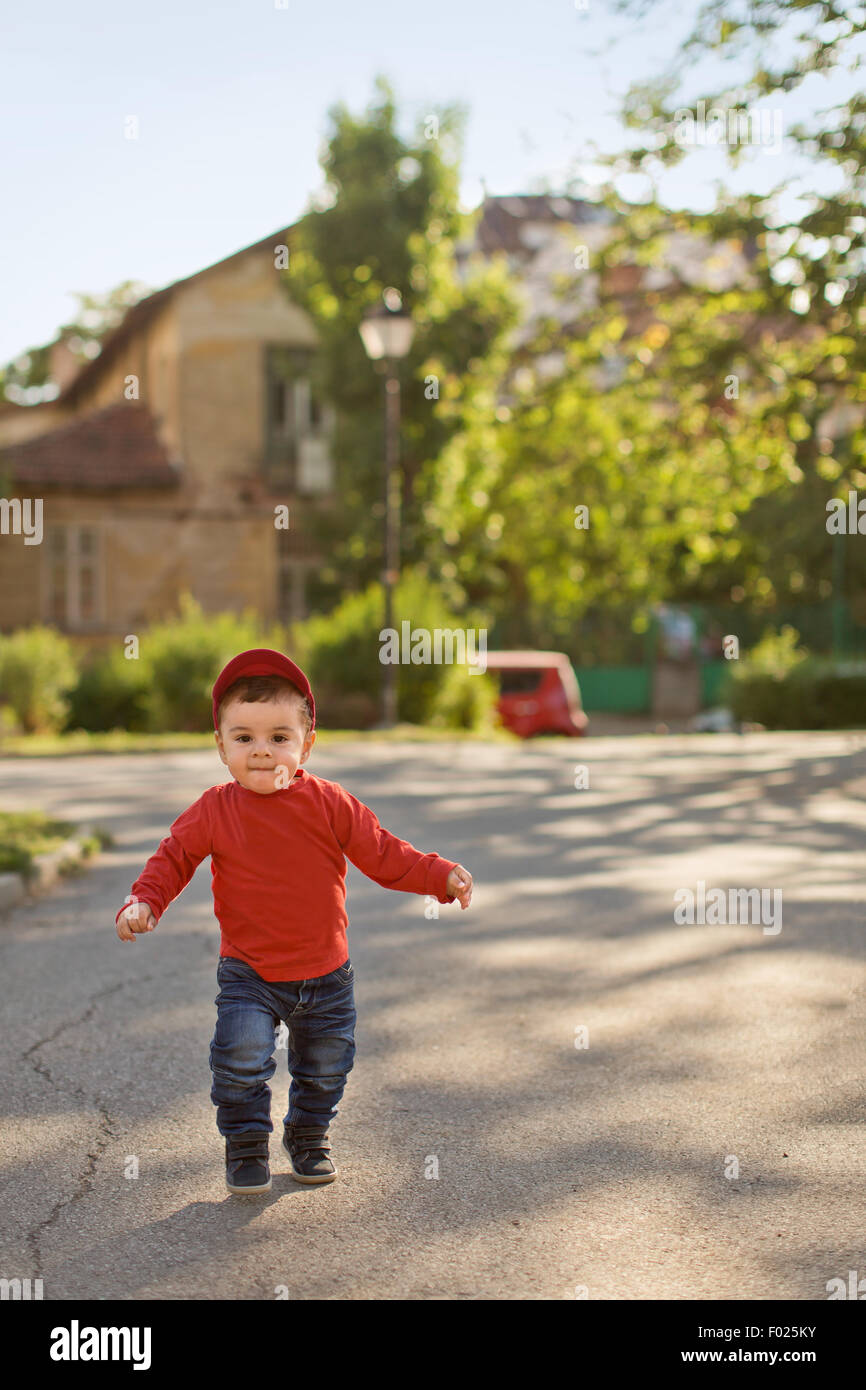 Baby Boy laufen Straße hinunter Stockfoto