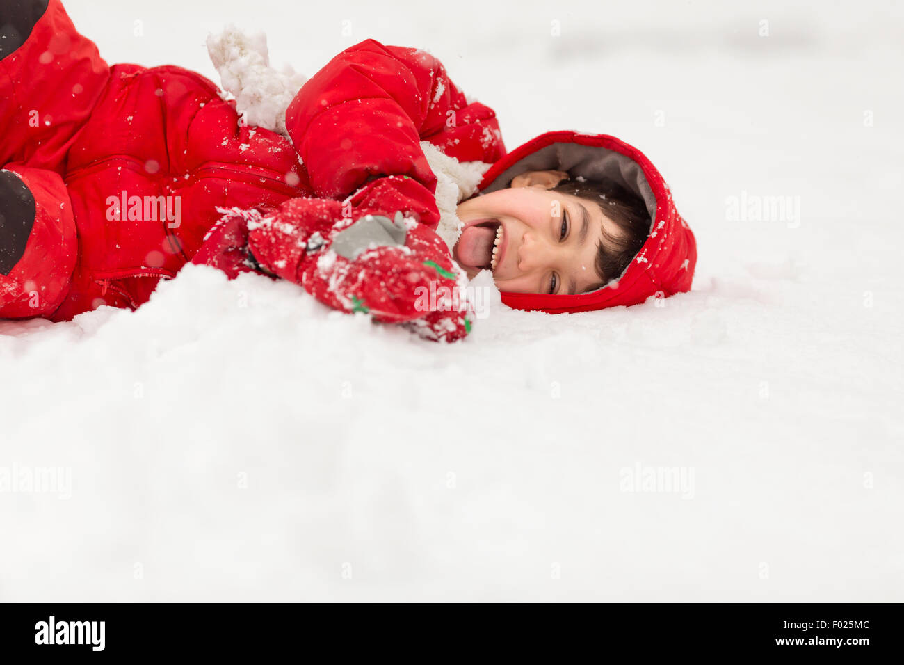 Junge liegend im Schnee Stockfoto