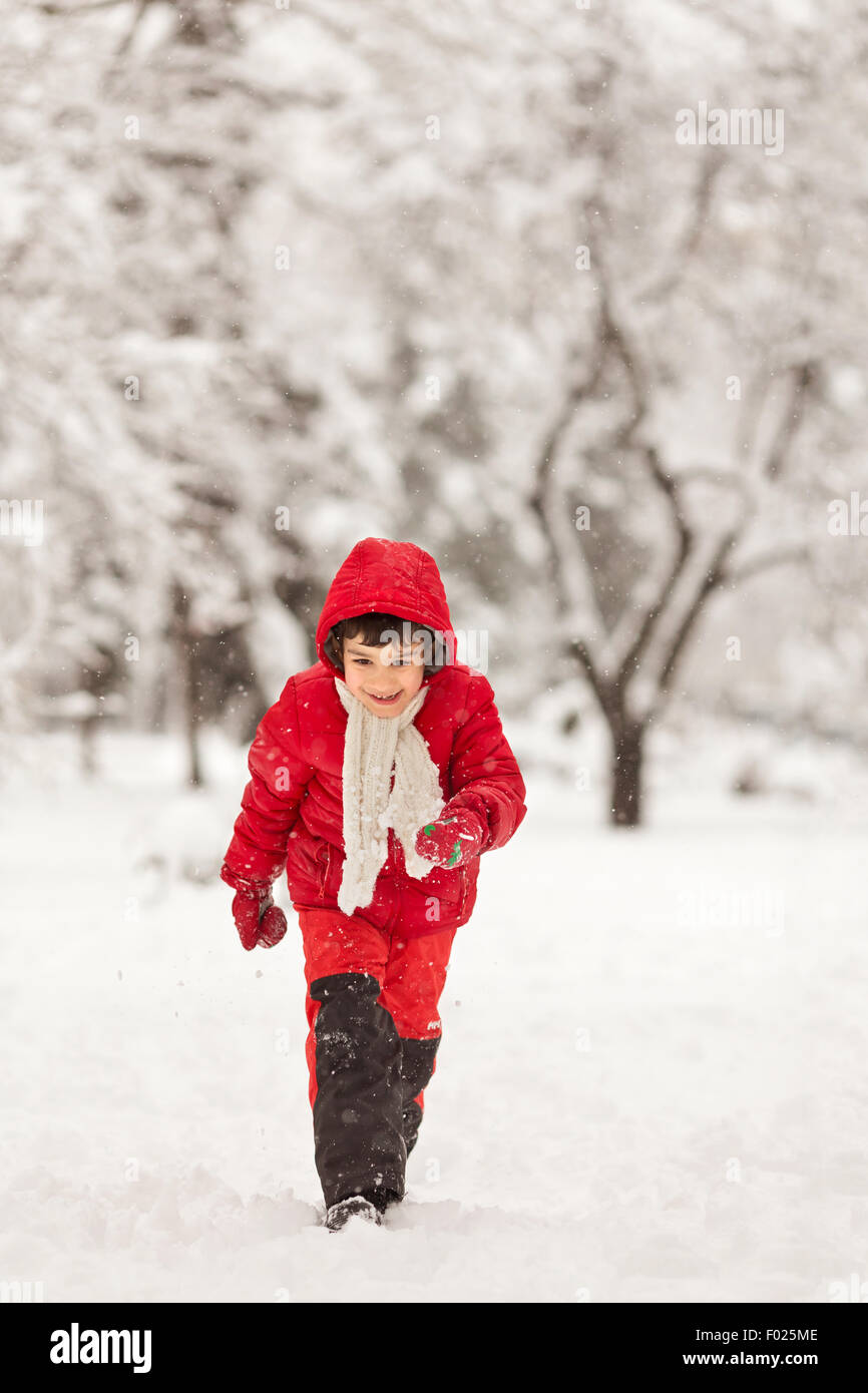 Junge läuft im Schnee Stockfoto