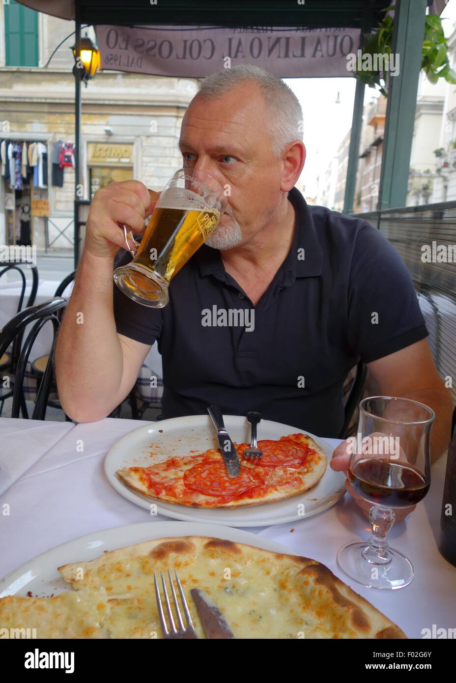 Mann trinkt Bier an einem strassenrand Cafe in Rom, Italien, Europa Stockfoto