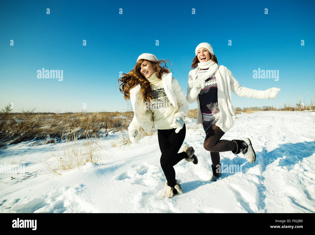 Zwei Freundinnen Spaß haben und genießen Sie frischen Schnee im schönen Wintertag Stockfoto