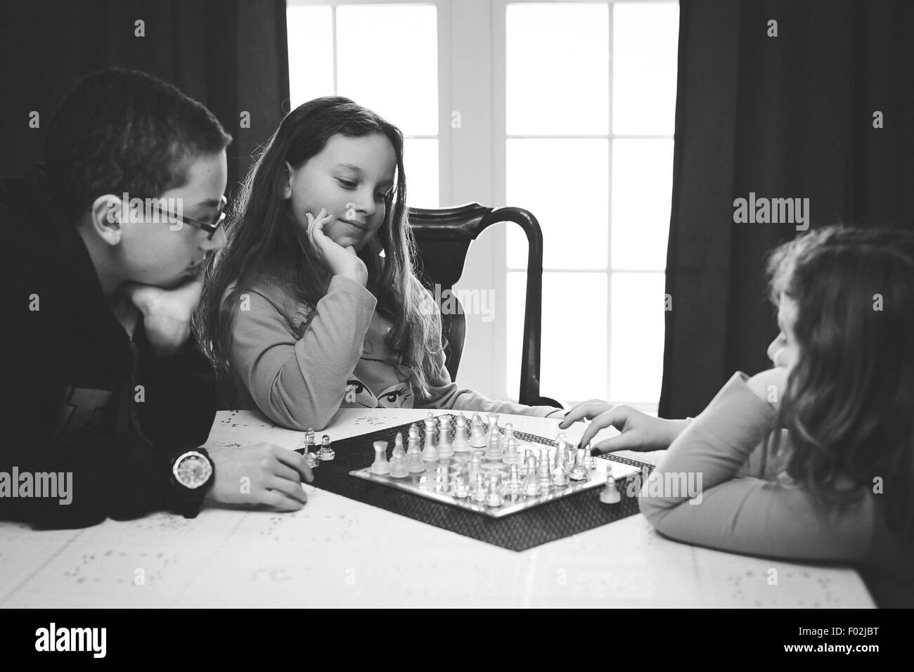 Drei Kinder spielen eine Partie Schach Stockfoto