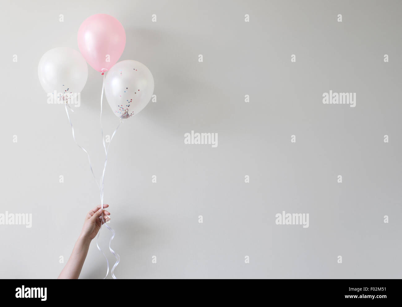 Hand, die Luftballons mit Konfetti im Inneren Stockfoto