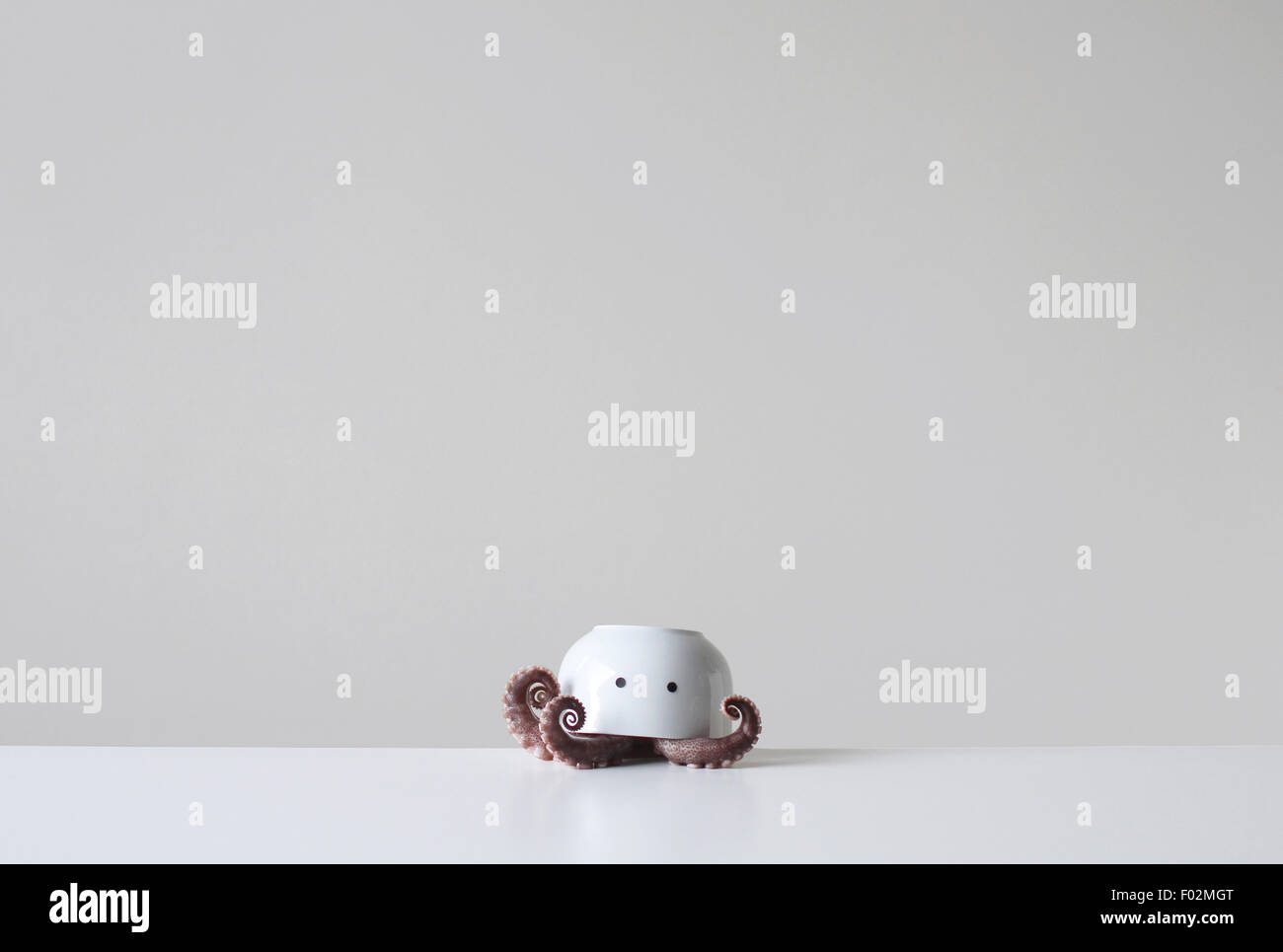 Tintenfisch Tentakeln unter eine Upside-down Schüssel mit zwei Augen Stockfoto