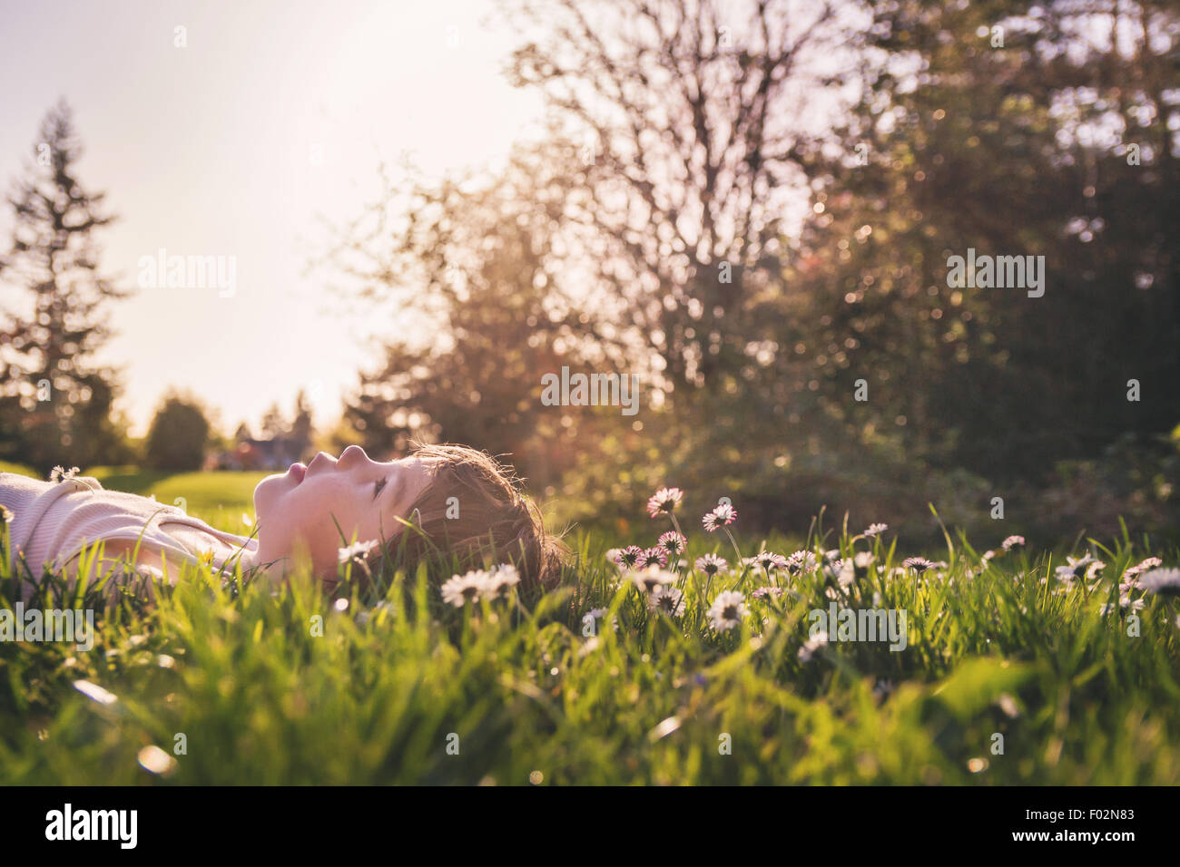 Junge auf einer Wiese liegend, der zum Himmel schaut, USA Stockfoto