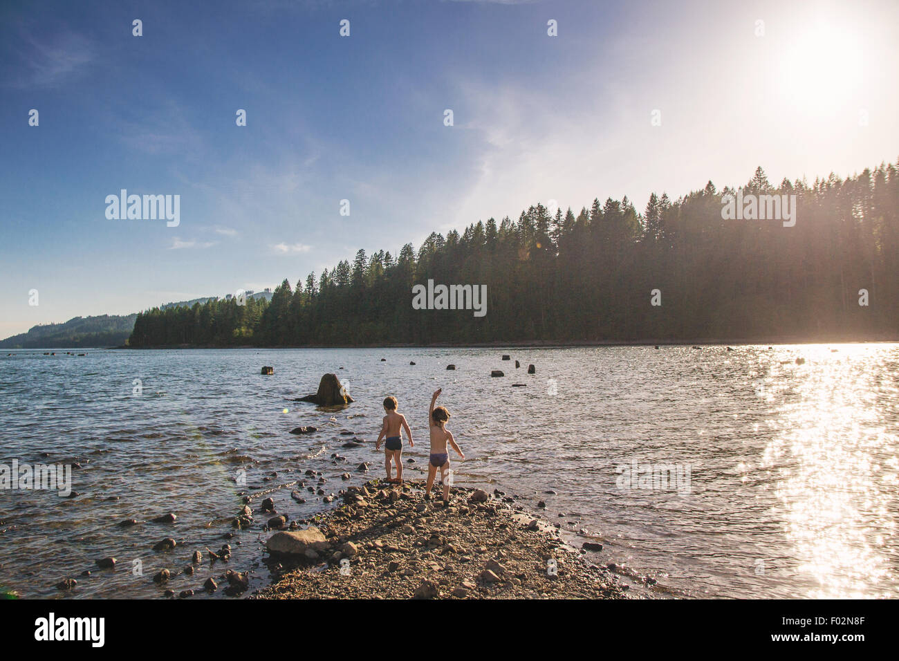 Zwei jungen stehen am Rand des Sees Stockfoto