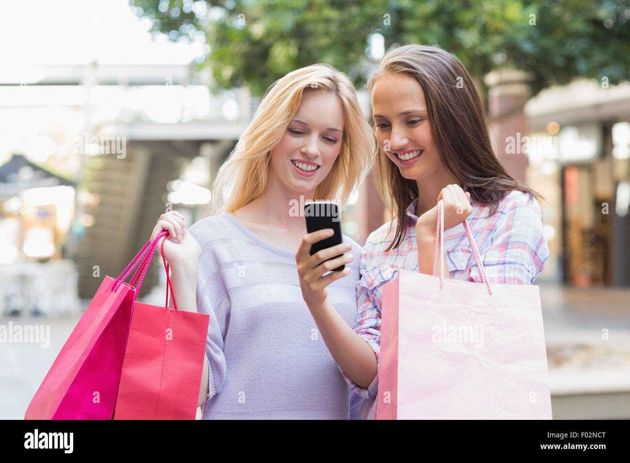 Glückliche Frauen Freunde Blick auf smartphone Stockfoto