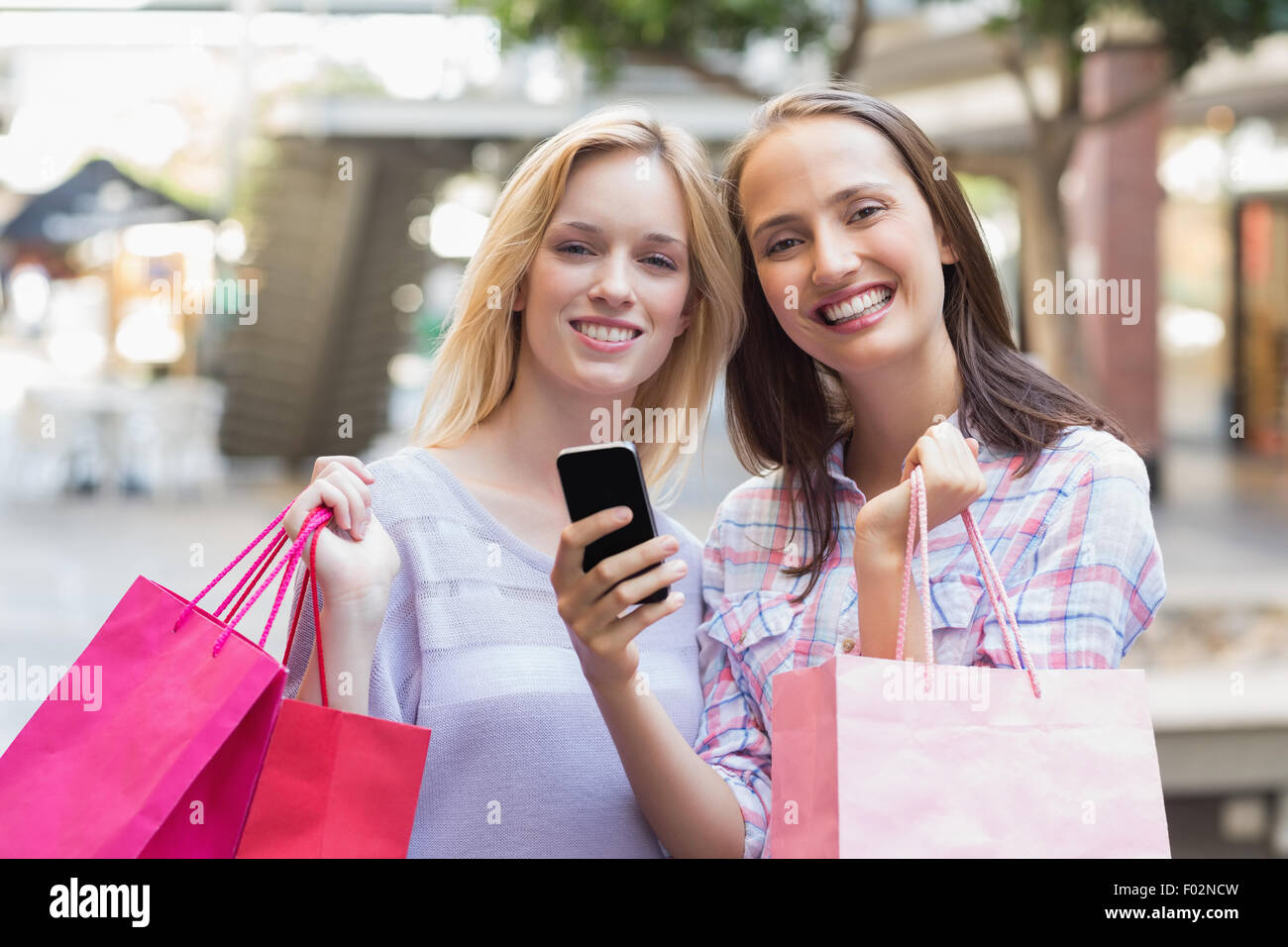 Glückliche Frauen Freunde lächelnd in die Kamera mit Einkaufstüten Stockfoto