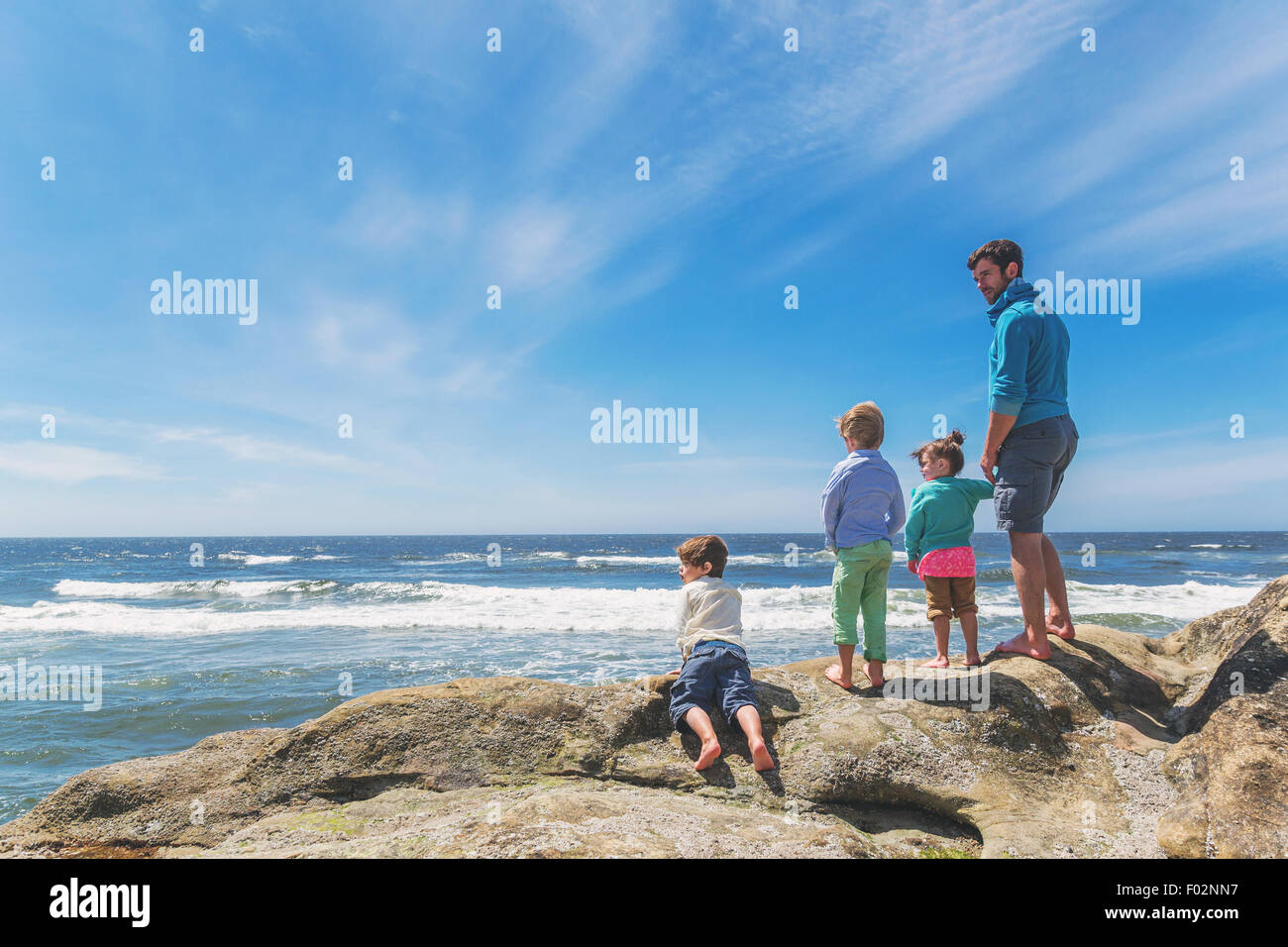 Vater und seinen drei Kindern am Strand Stockfoto