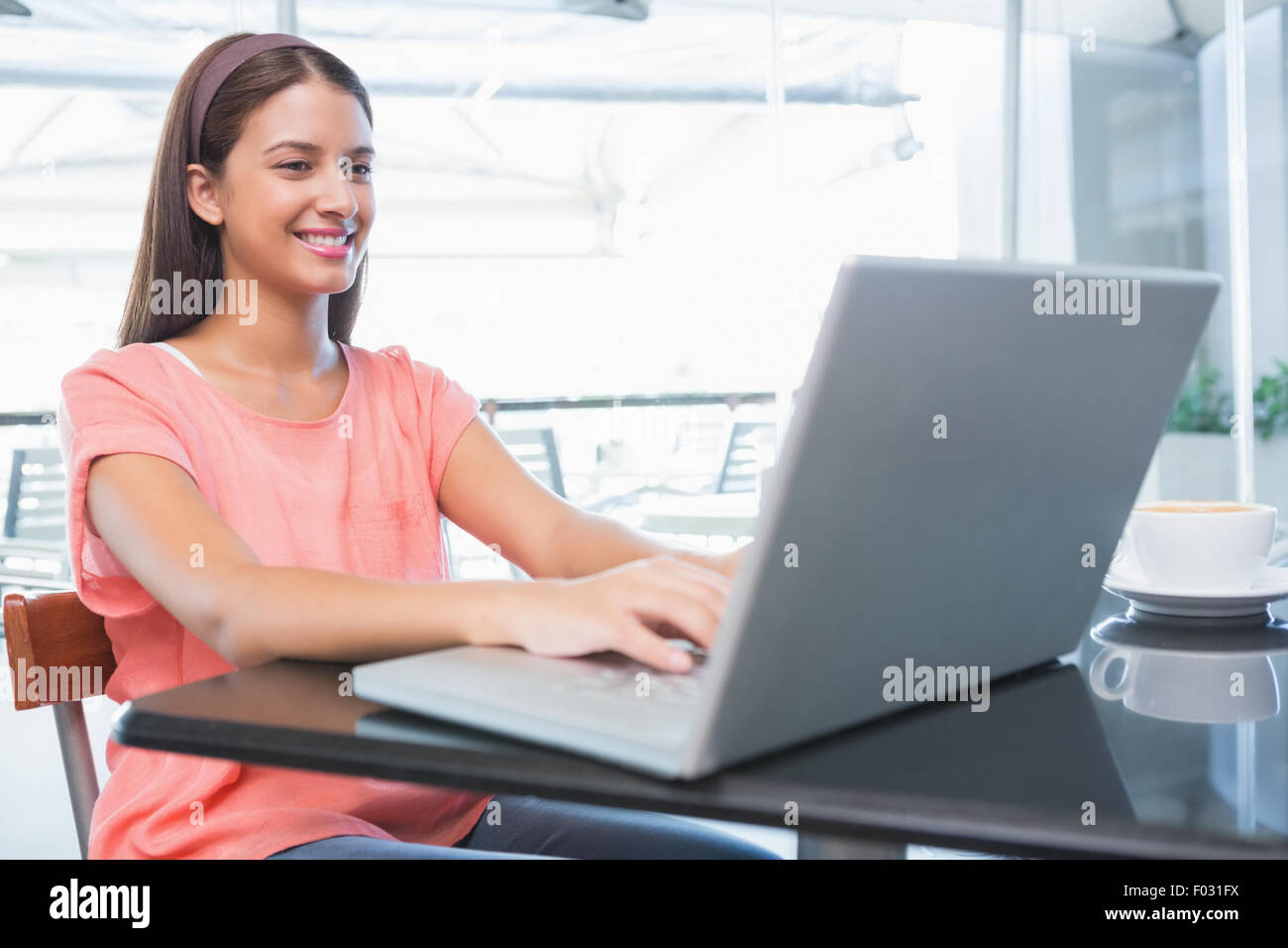 Junge glückliche Frau, die Eingabe auf dem laptop Stockfoto