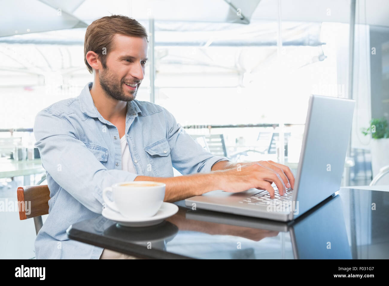 Glücklich Jüngling auf dem Laptop eingeben Stockfoto