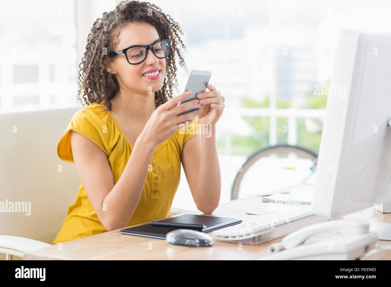 Lächelnde junge Geschäftsfrau, die einen Text senden Stockfoto