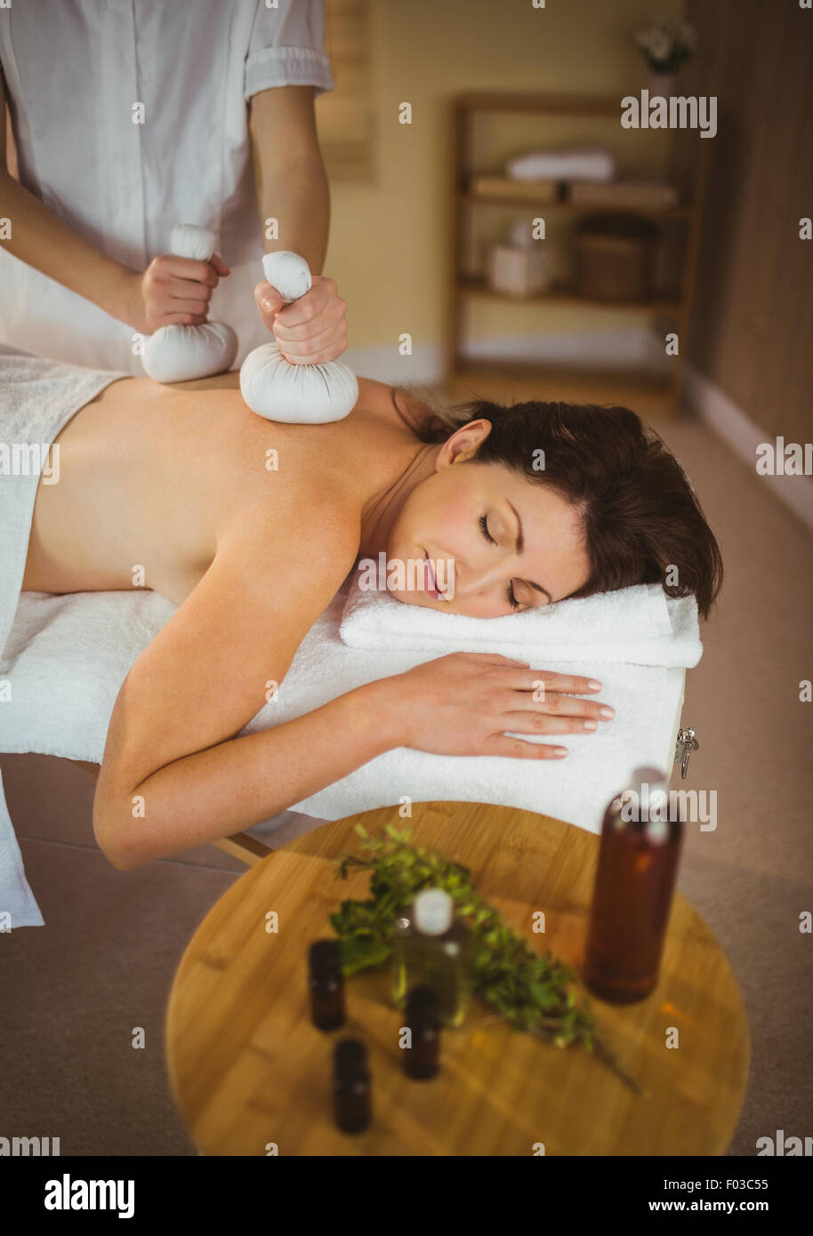 Junge Frau, die immer herbal Compress massage Stockfoto