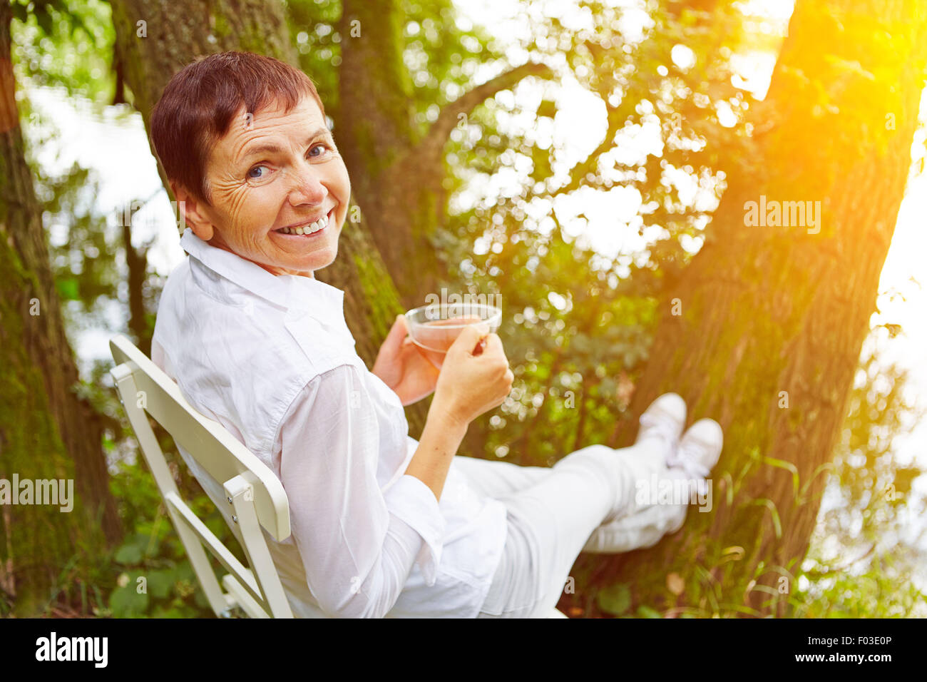 Entspannte senior Frau eine Pause mit Tee in ihrem Garten Stockfoto