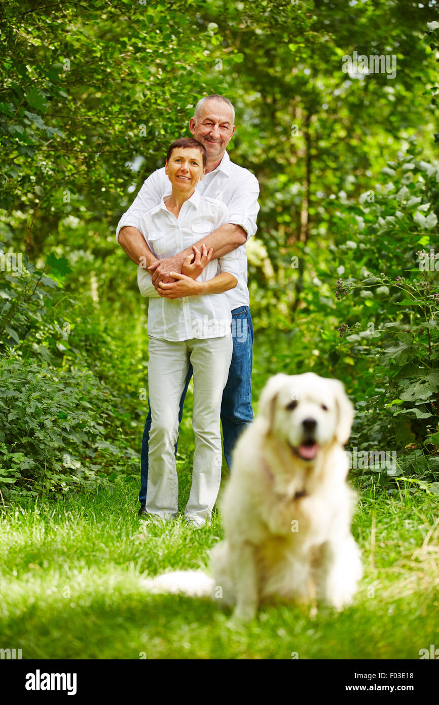 Älteres Paar mit golden Retriever Hund als Haustier in ihrem Garten Stockfoto