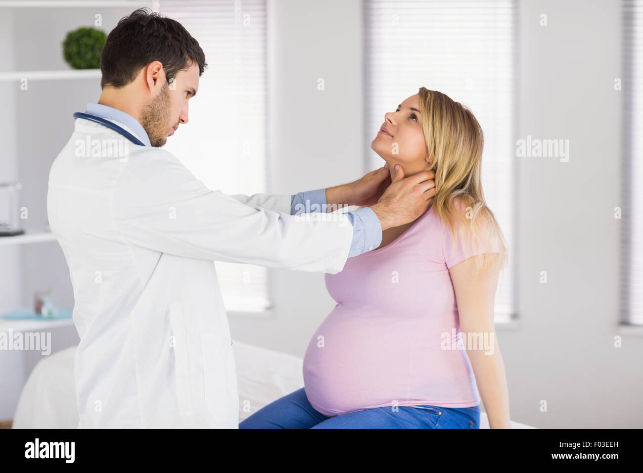 Arzt untersucht Hals der schwangeren Patientin Stockfoto