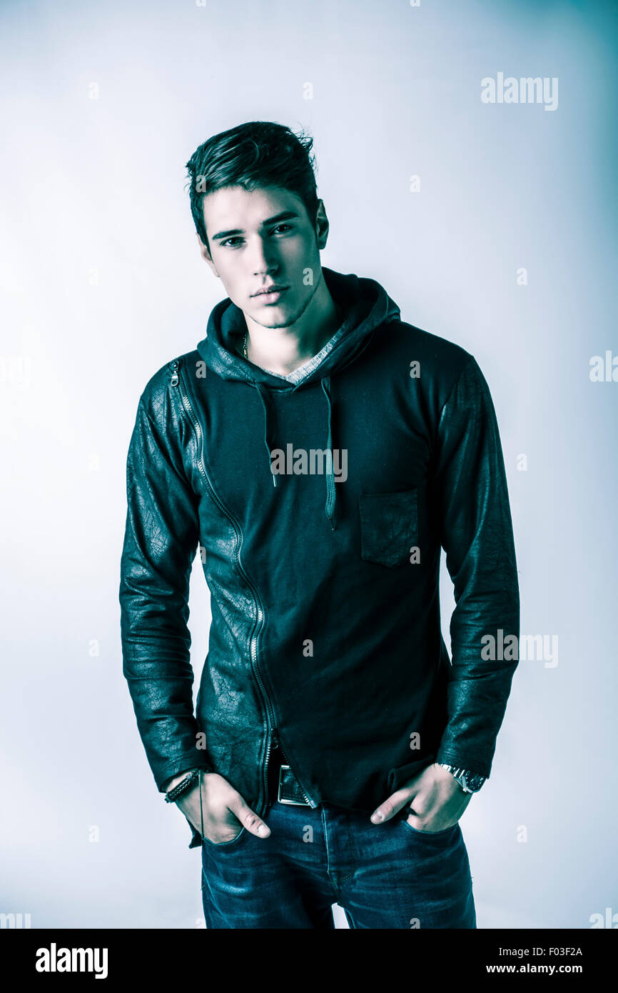 Hübscher junger Mann in schwarzer Hoodie Pullover auf hellem Hintergrund, Blick in die Kamera. Studio gedreht Stockfoto
