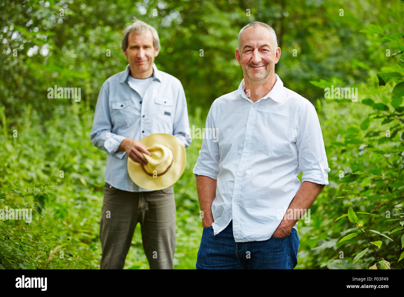 Zwei alte Männer stehen im Sommer in der Natur in einem Wald Stockfoto